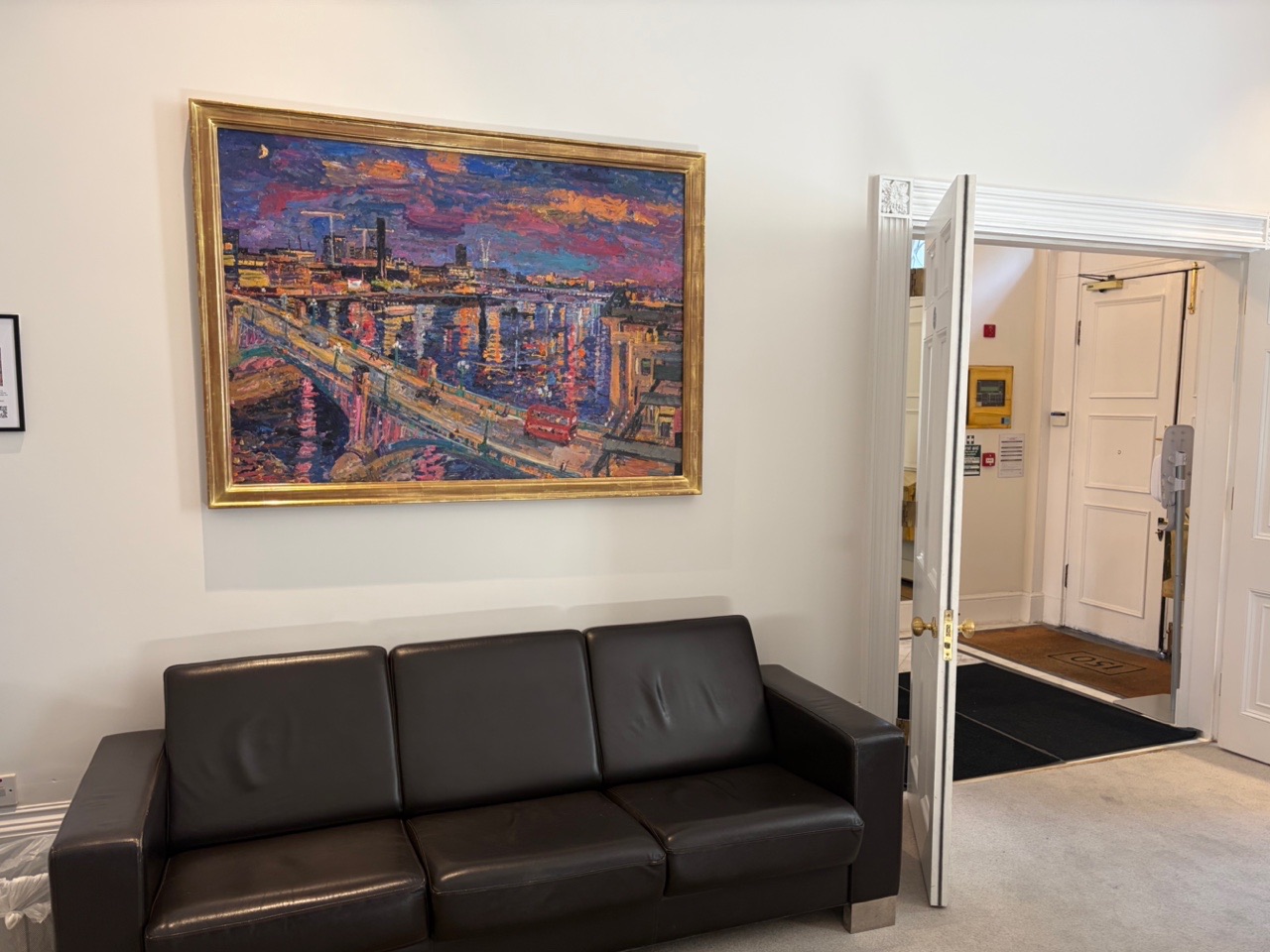 Peter Spens' night painting of a Thames bridge with a red bus, hanging at 150 Harley Street